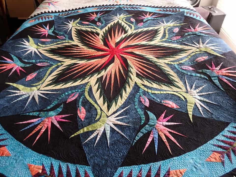 Quilt With Large Floral Design in Blue, Black, Orange, and Green — Morning Star Quilting in Bateau Bay, NSW