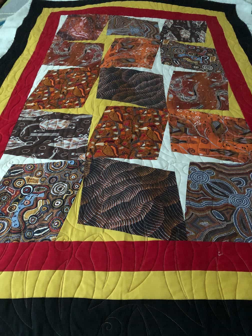 Quilt With Batik-style Fabric Blocks, Bordered by Red, Yellow, and Black — Morning Star Quilting in Bateau Bay, NSW