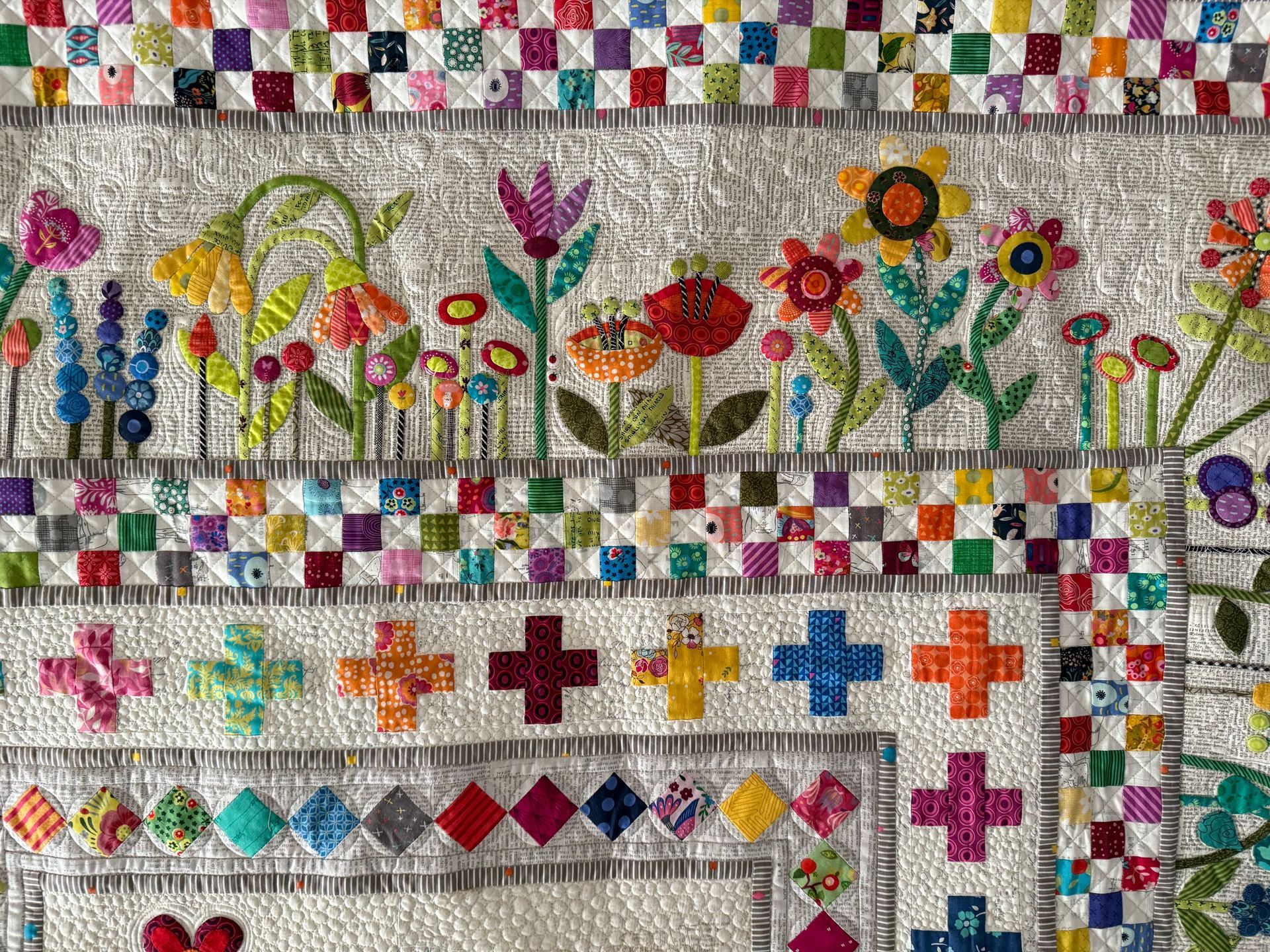 Close-up of a colourful quilt with floral appliqué and patchwork borders — Morning Star Quilting in Bateau Bay, NSW