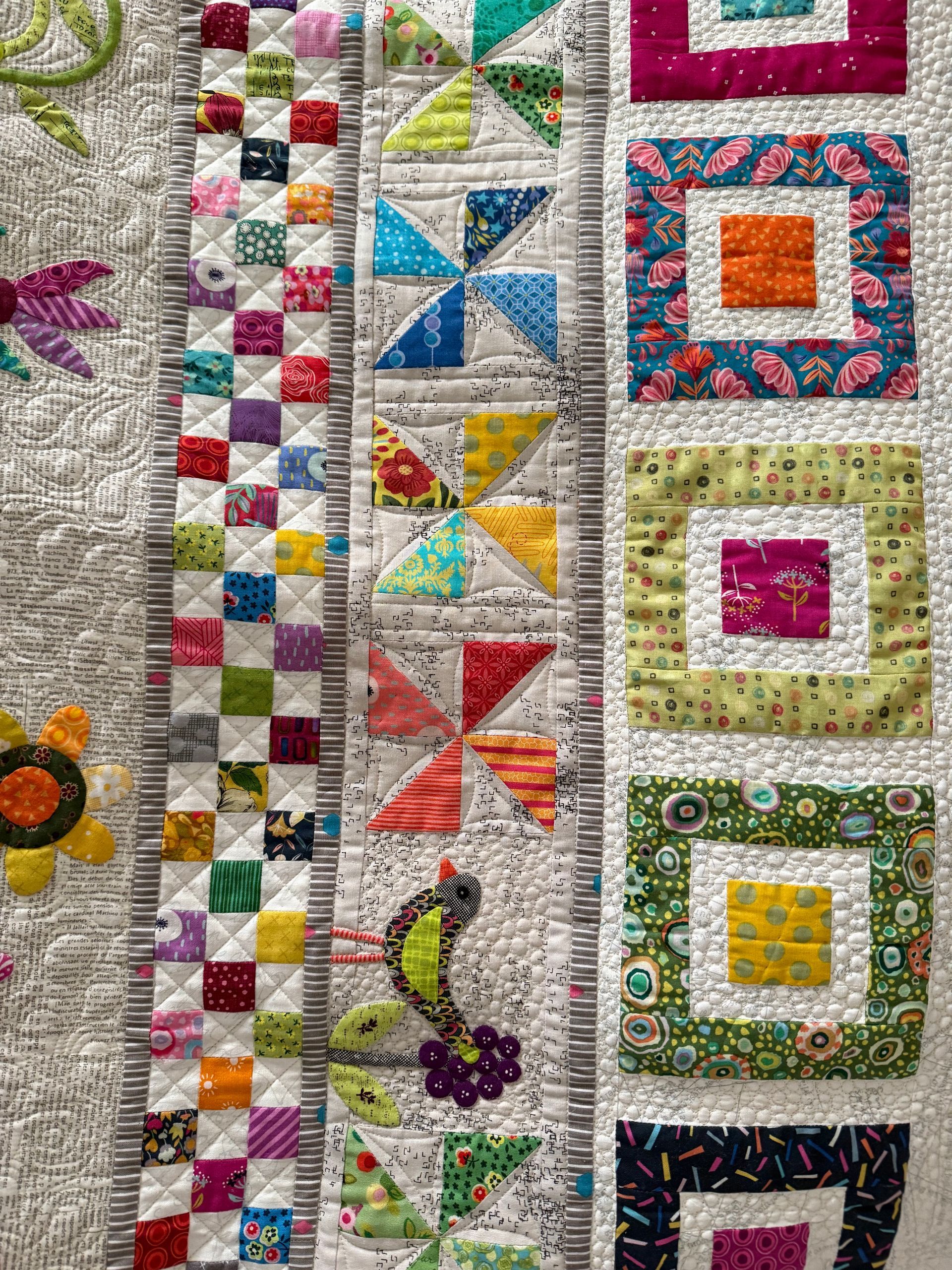 Close-up of a colourful quilt with various patterns and designs, including squares, pinwheels, and a seahorse — Morning Star Quilting in Bateau Bay, NSW