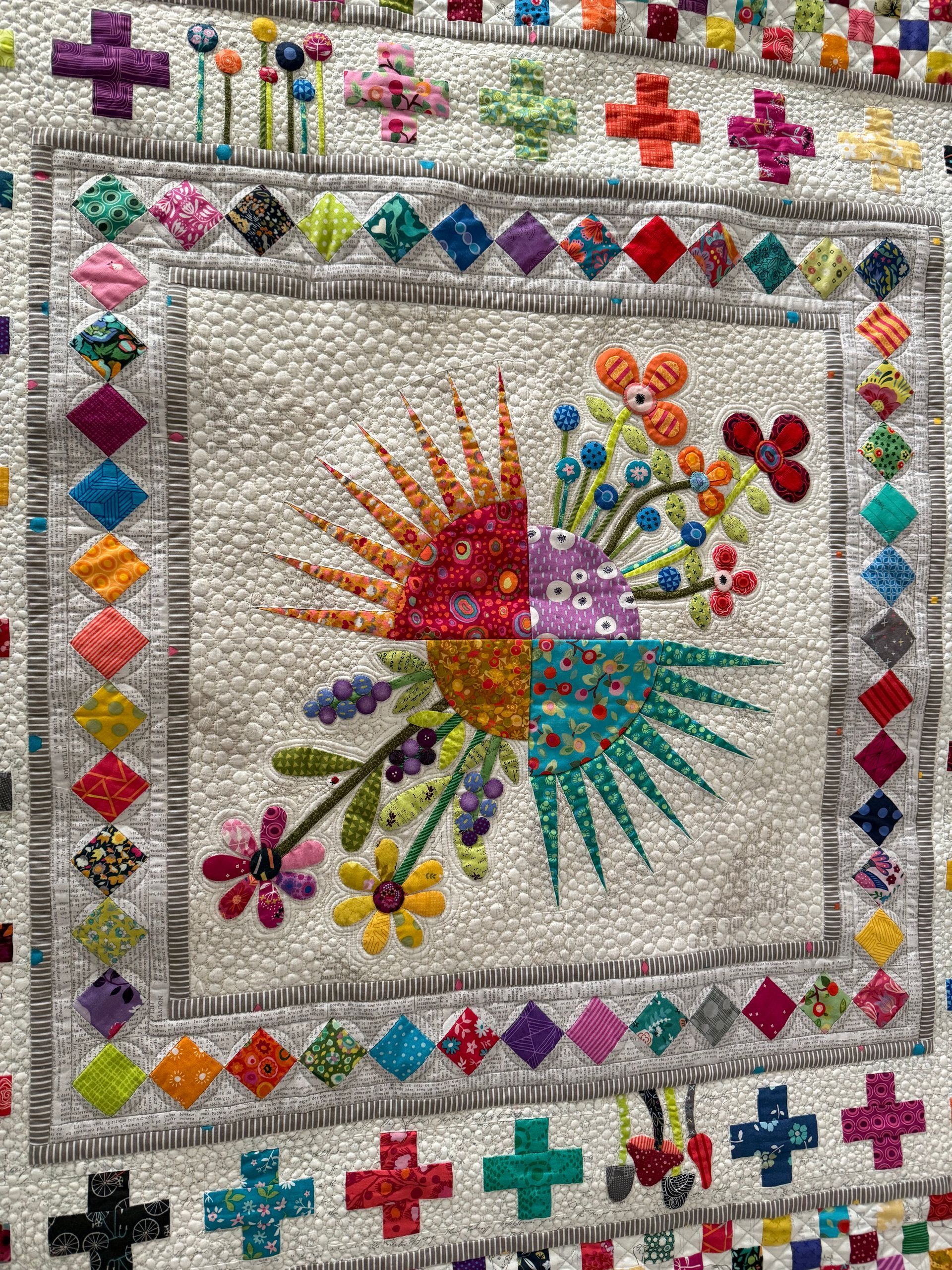 Colourful quilt with a floral design and geometric borders — Morning Star Quilting in Bateau Bay, NSW