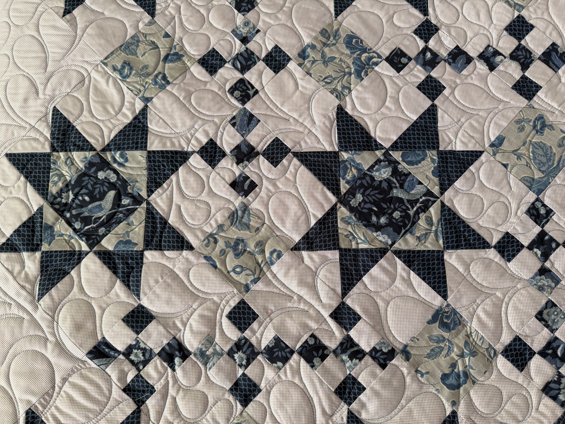 Close-up of a blue and white quilted textile with star and diamond patterns, detailed stitching — Morning Star Quilting in Bateau Bay, NSW