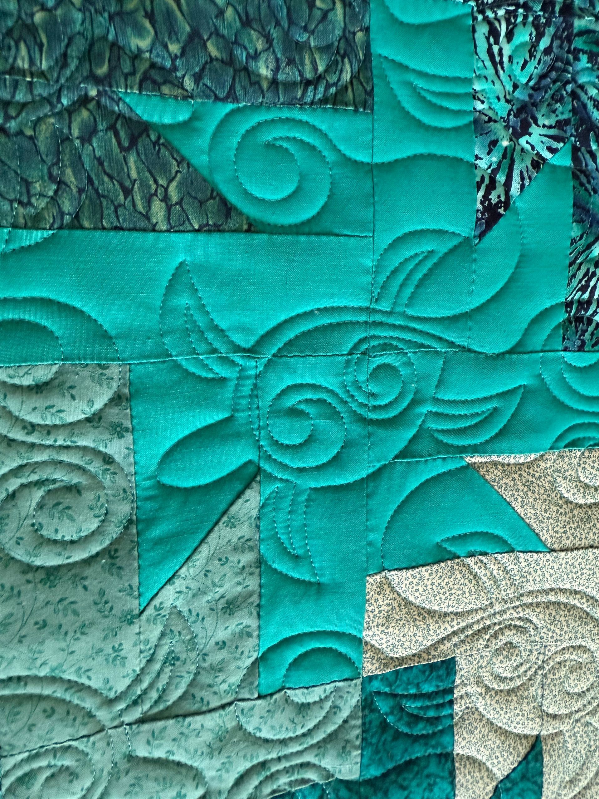 Close-up of a teal and grey quilted starburst pattern with detailed swirling designs — Morning Star Quilting in Bateau Bay, NSW