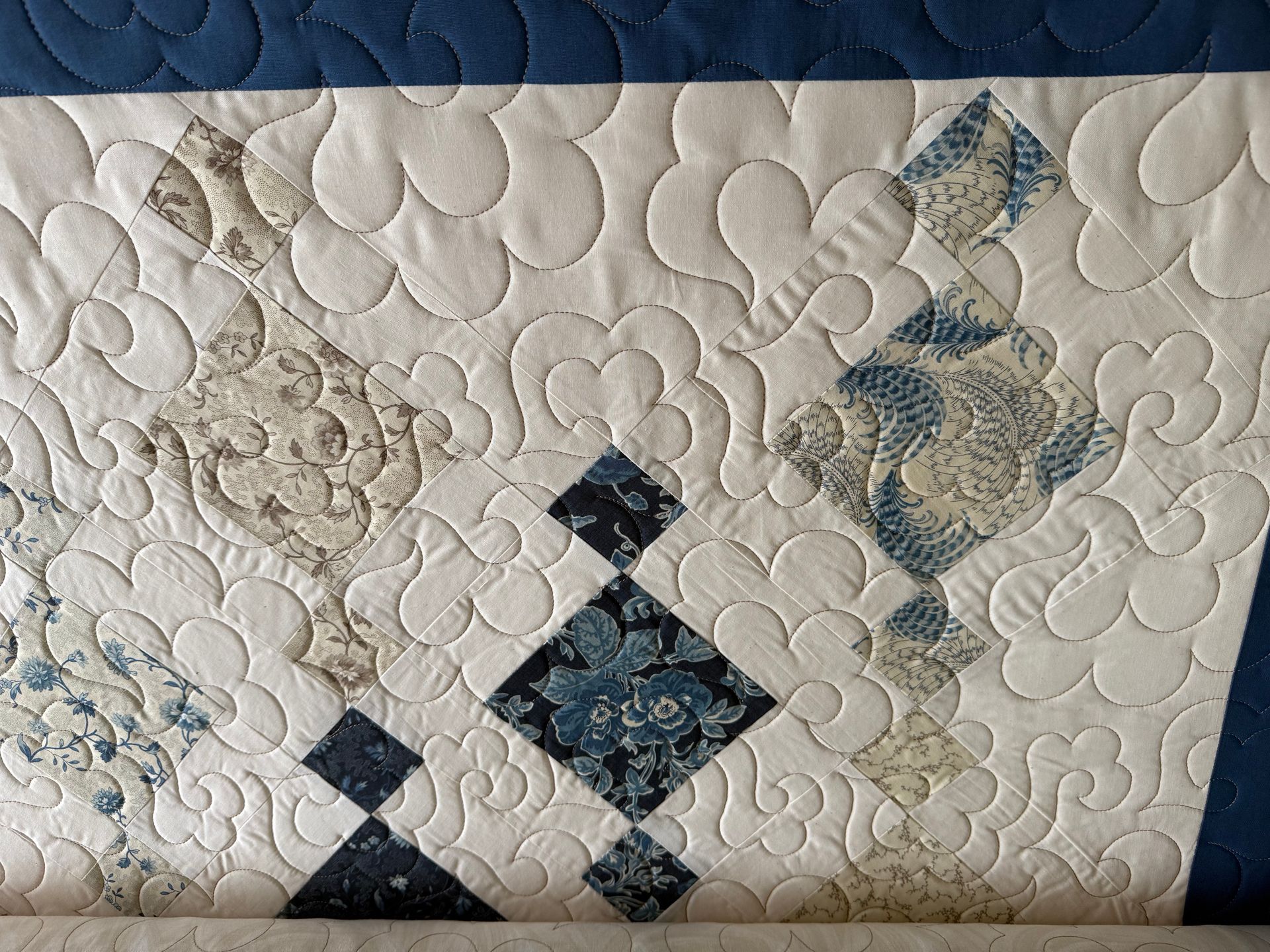 Quilted fabric with floral patterns on white and blue backgrounds, quilted with a swirling design — Morning Star Quilting in Bateau Bay, NSW