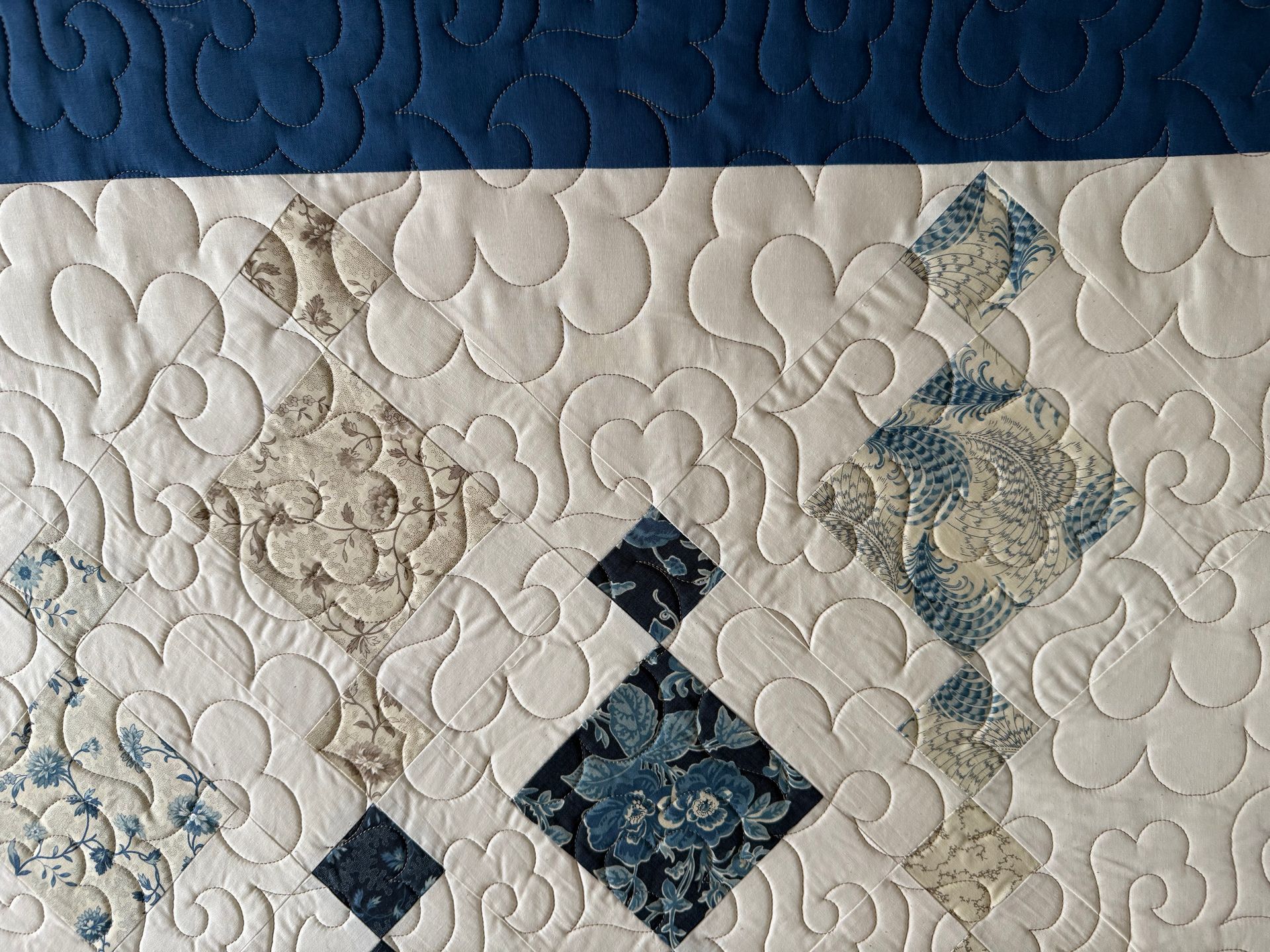 Quilted textile detail with blue and white diamond patterns and floral designs on cream background — Morning Star Quilting in Bateau Bay, NSW
