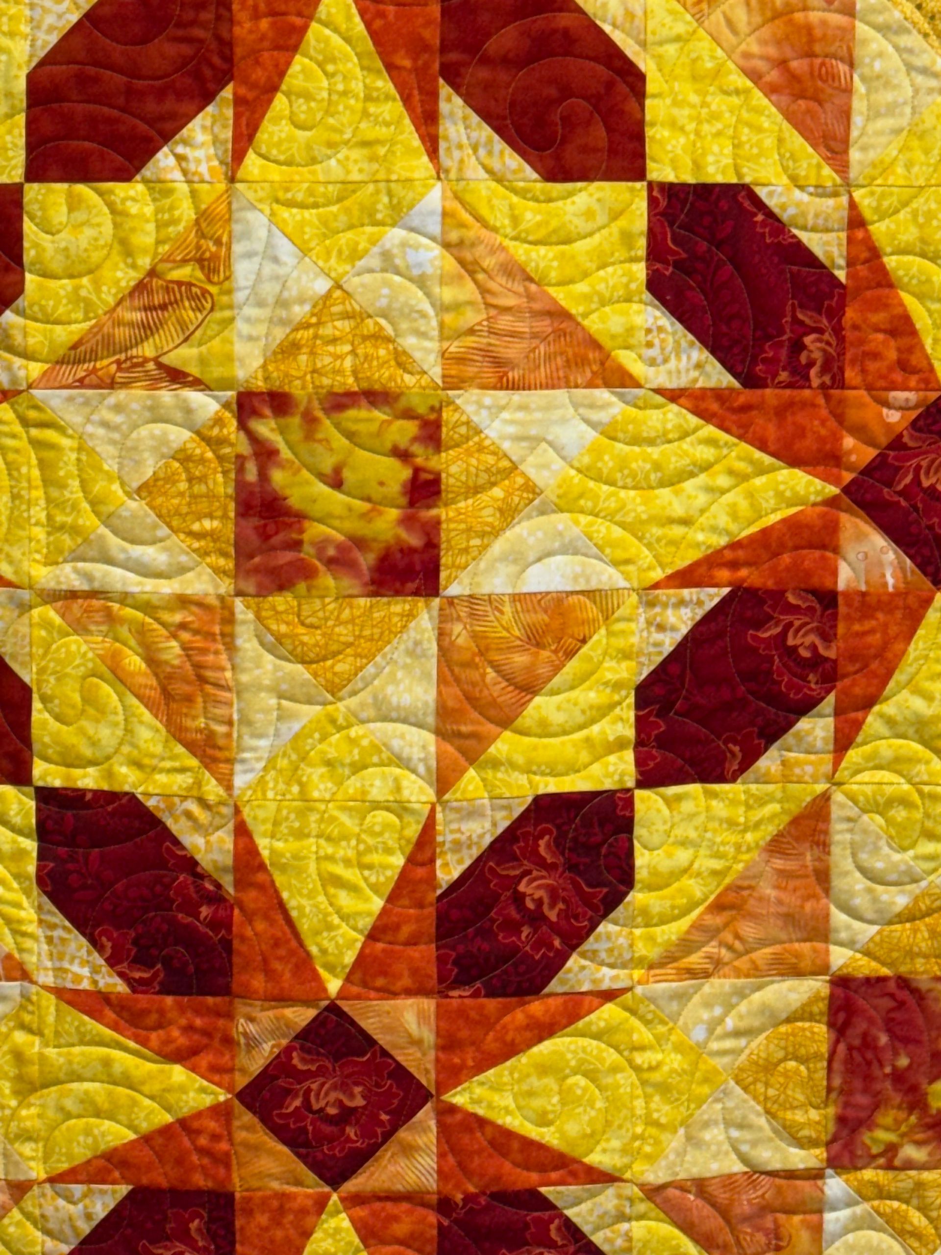 Quilted fabric in shades of yellow and burgundy, geometric starburst pattern — Morning Star Quilting in Bateau Bay, NSW
