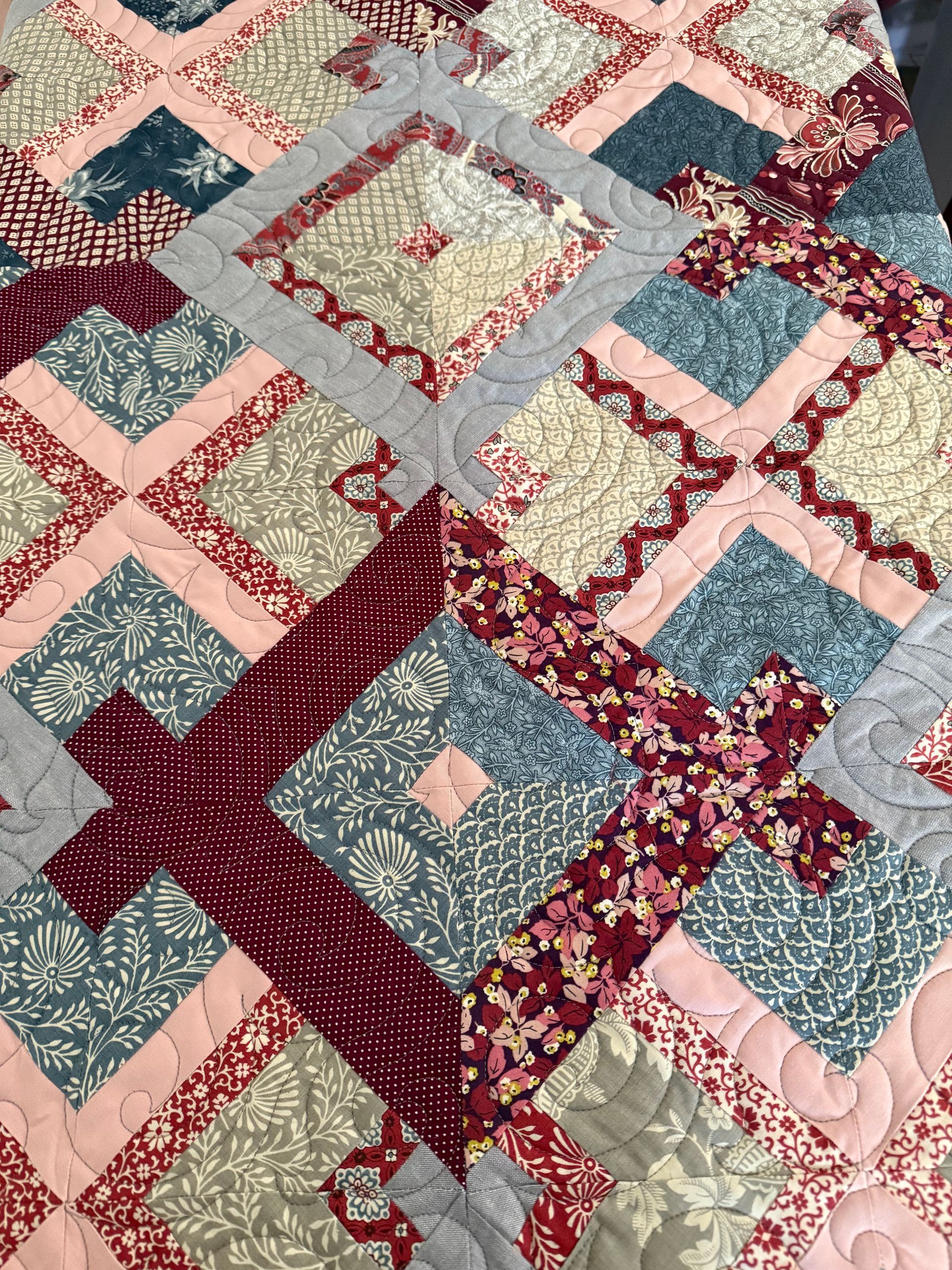 Quilt with a diamond pattern in shades of pink, blue, grey, and burgundy — Morning Star Quilting in Bateau Bay, NSW