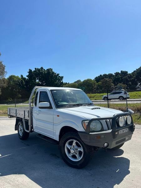 A White Truck Is Parked On The Side Of The Road — Chinderah Smash Repairs in Chinderah, NSW