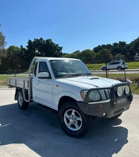 A White Truck Is Parked on The Side of The Road — Chinderah Smash Repairs in Chinderah, NSW