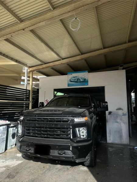 A Black Truck Is Parked Under A Roof In A Garage — Chinderah Smash Repairs in Chinderah, NSW