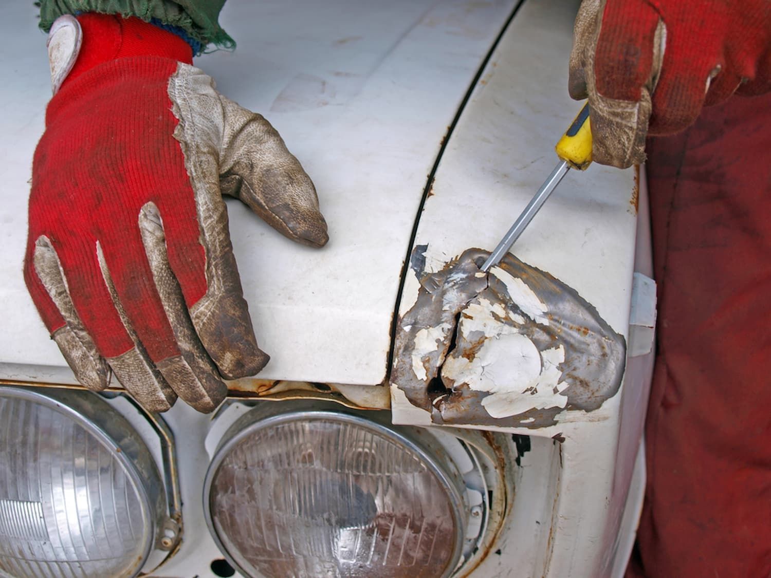 A Person Wearing Red Gloves Is Working on A Car — Chinderah Smash Repairs in Chinderah, NSW