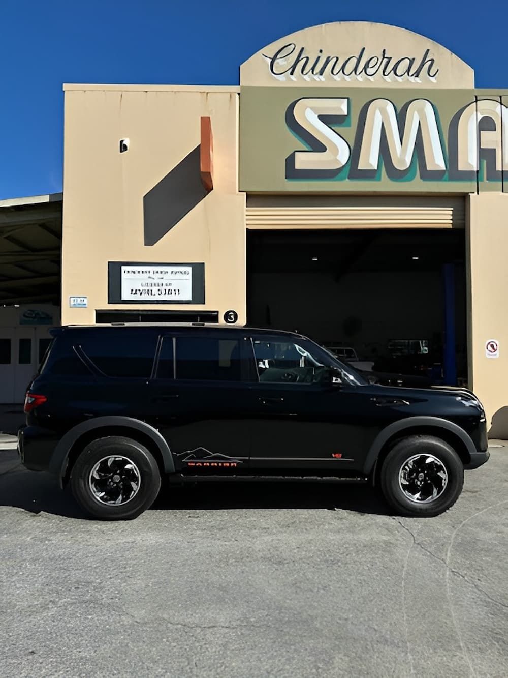 A Black SUV Is Parked in Front of A Building — Chinderah Smash Repairs in Chinderah, NSW
