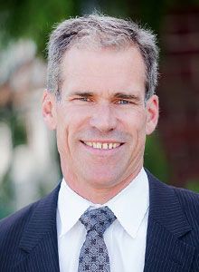 A man in a suit and tie is smiling for the camera.