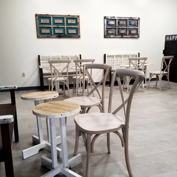 cafe interior with light wood chairs, stools, and benches.