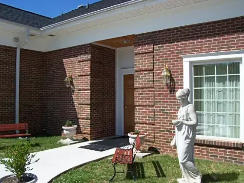 a statue of a woman standing in front of a brick building