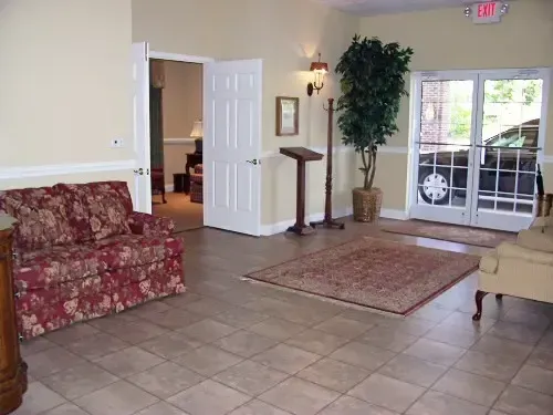 a living room with a red couch and a red exit sign