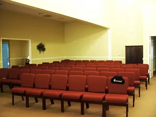 rows of red chairs in an auditorium with a sign that says reserved