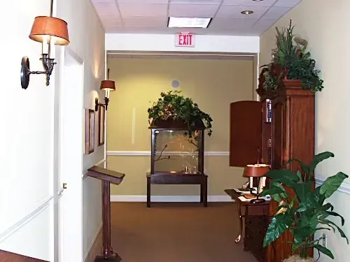 a hallway with a red exit sign on the wall