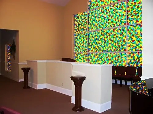 a room with a podium and a stained glass wall