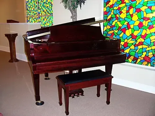 a piano is sitting in front of a colorful painting
