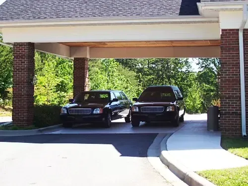 two cars are parked under a brick building