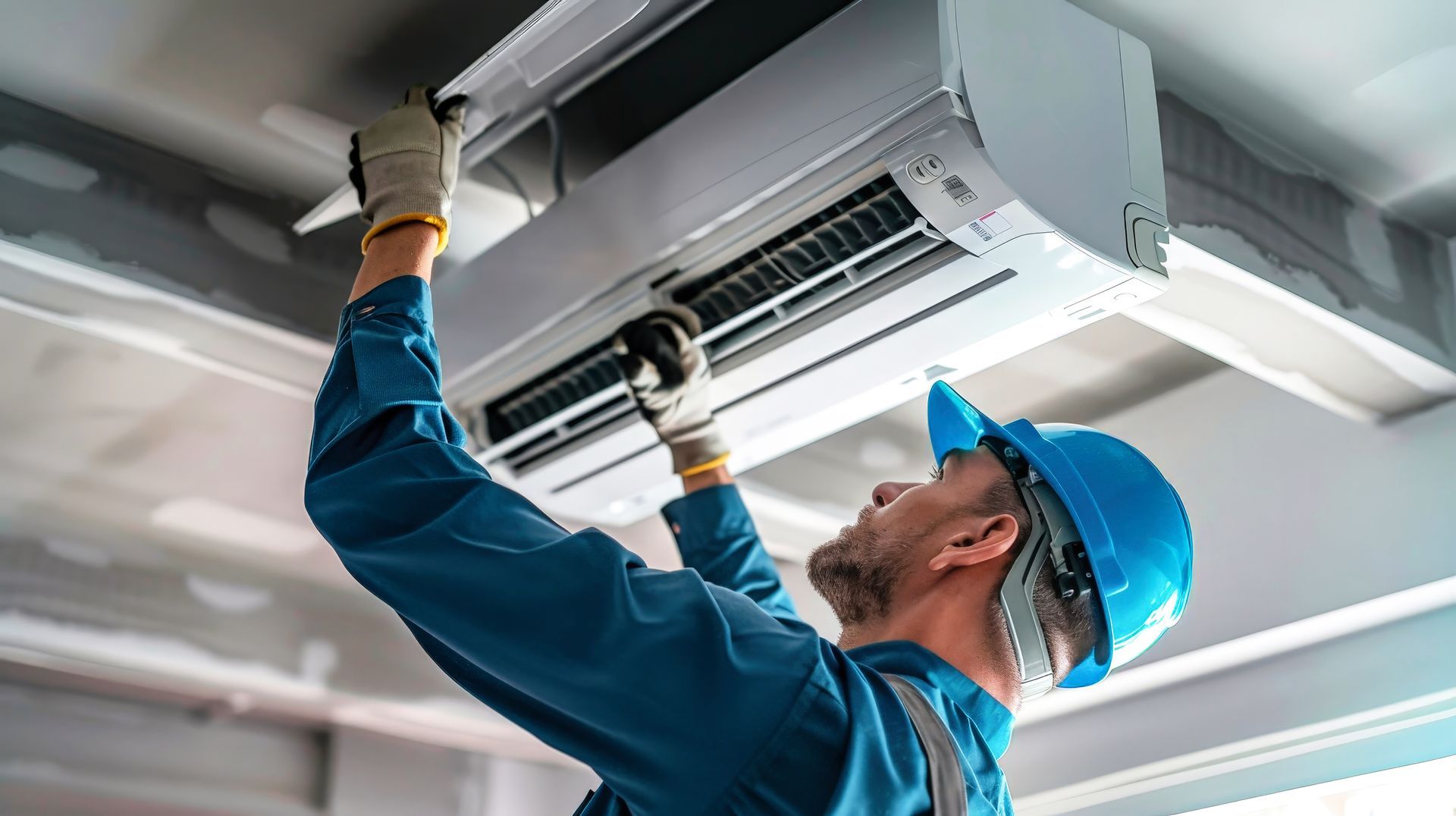 A man is installing an air conditioner on the ceiling.