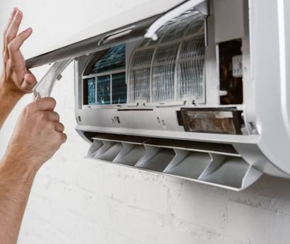 Worker Fixing White Air Conditioner — Fort Myers, FL — Weather Control Air Conditioning, Inc.