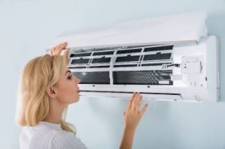 Woman Inspecting Air Condition — Fort Myers, FL — Weather Control Air Conditioning, Inc.