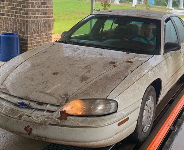 A white car is sitting on top of a tow truck.