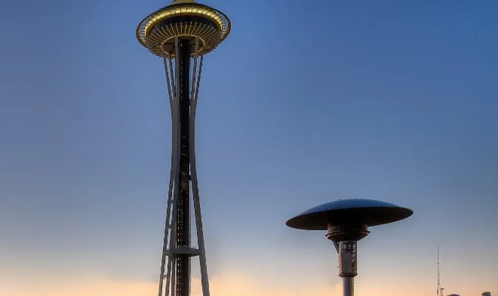 Rooftop terrace with a heater and railing overlooking the city skyline at sunset.