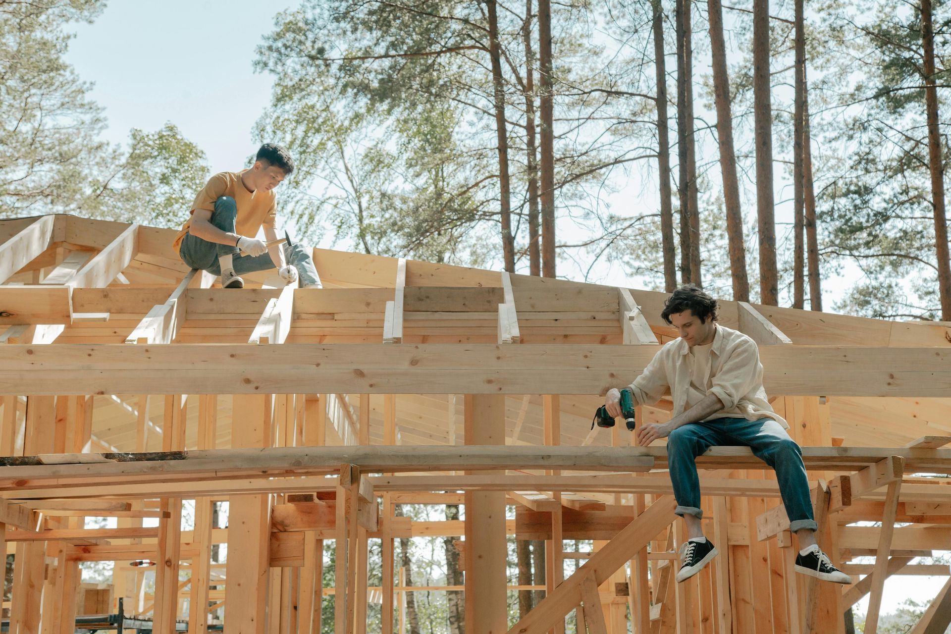 Two men are working on a wooden house under construction.
