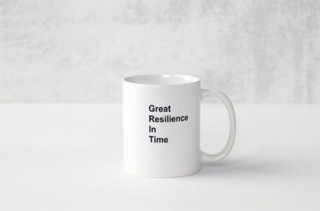 A white coffee mug with the words `` great resilience in time '' written on it.