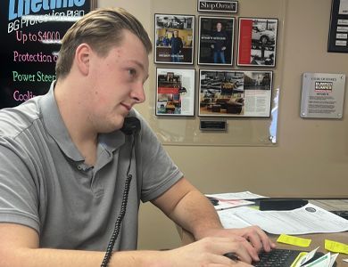 A man sitting at a desk talking on a phone