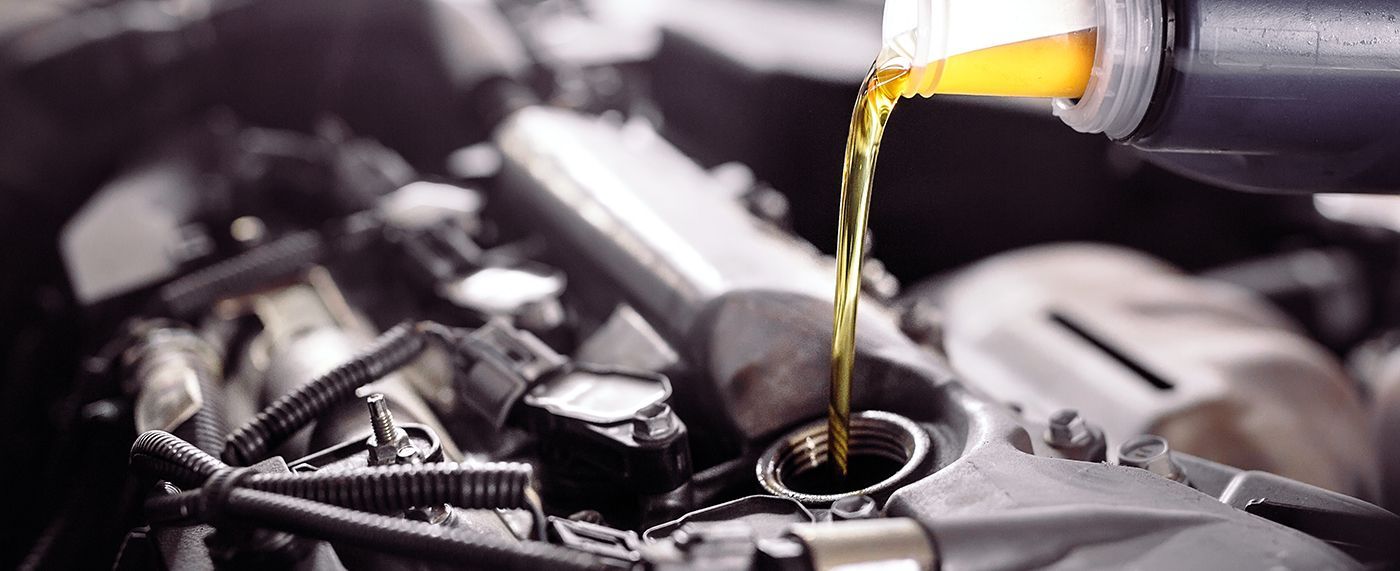 Engine oil being poured into a car engine.