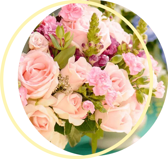 A bouquet of pink and purple flowers in a gold circle