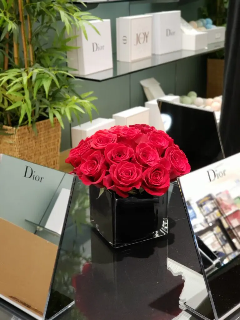 A bunch of red roses in a black vase on a table