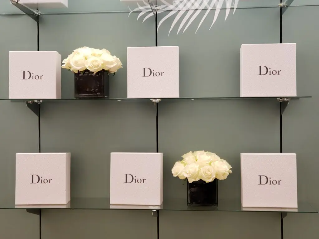 A display of dior boxes and flowers on shelves