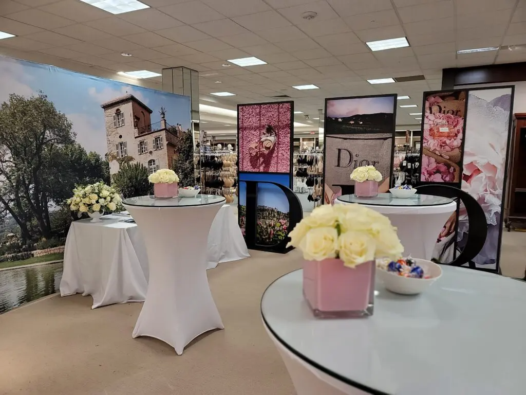 A room with tables and vases of flowers in it
