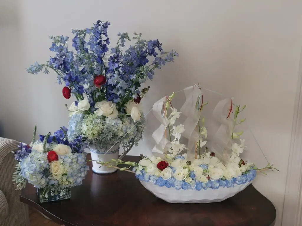 Three vases filled with blue and white flowers are sitting on a table.