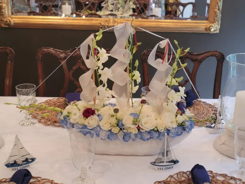 A table with flowers and a sailboat on it