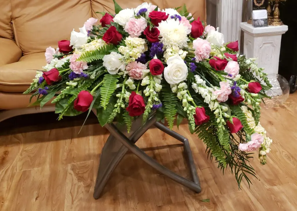 A large bouquet of flowers is sitting on a table in a living room.