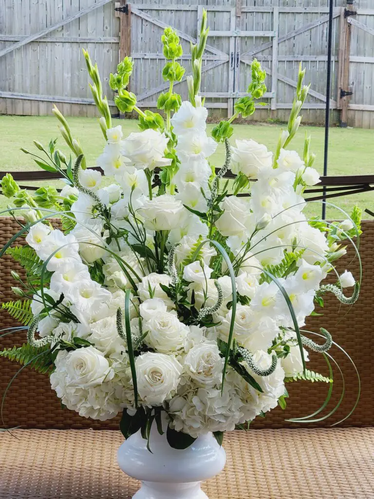 A vase filled with white flowers is sitting on a table.