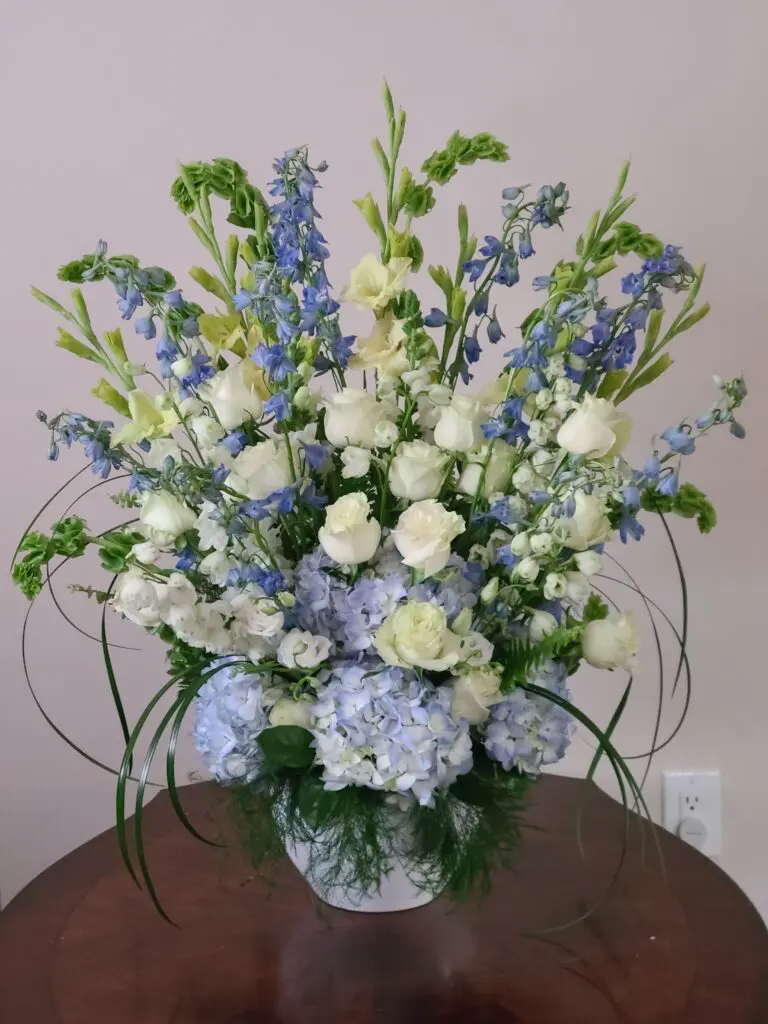 A vase filled with blue and white flowers sits on a table