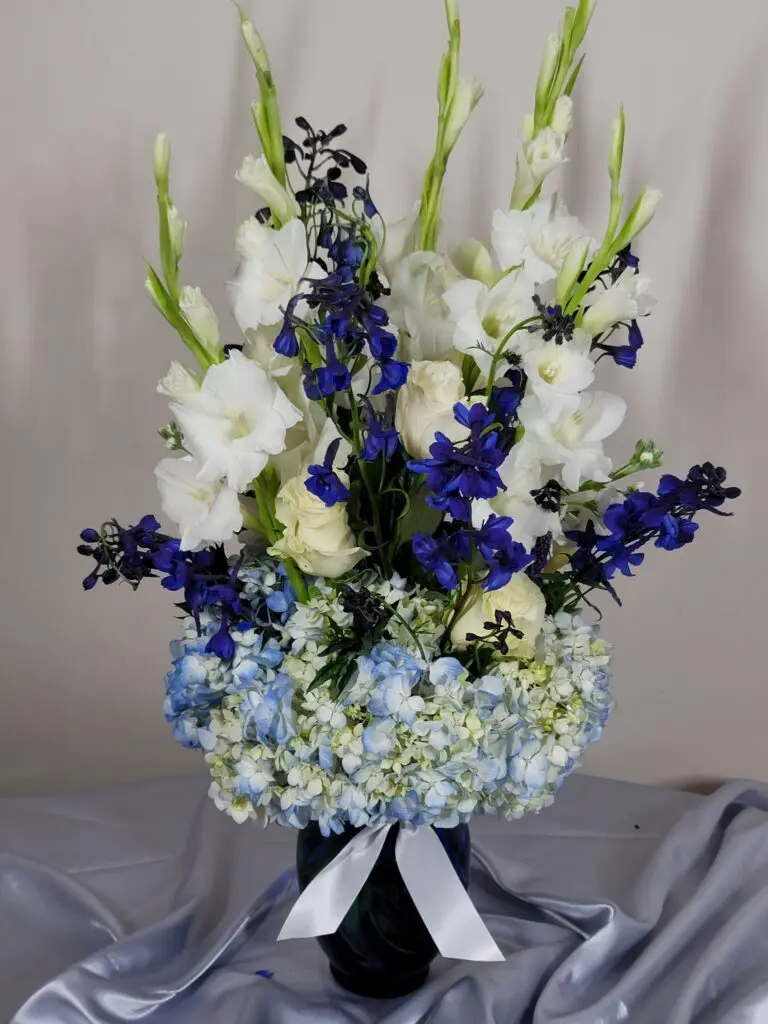 A vase filled with blue and white flowers on a table