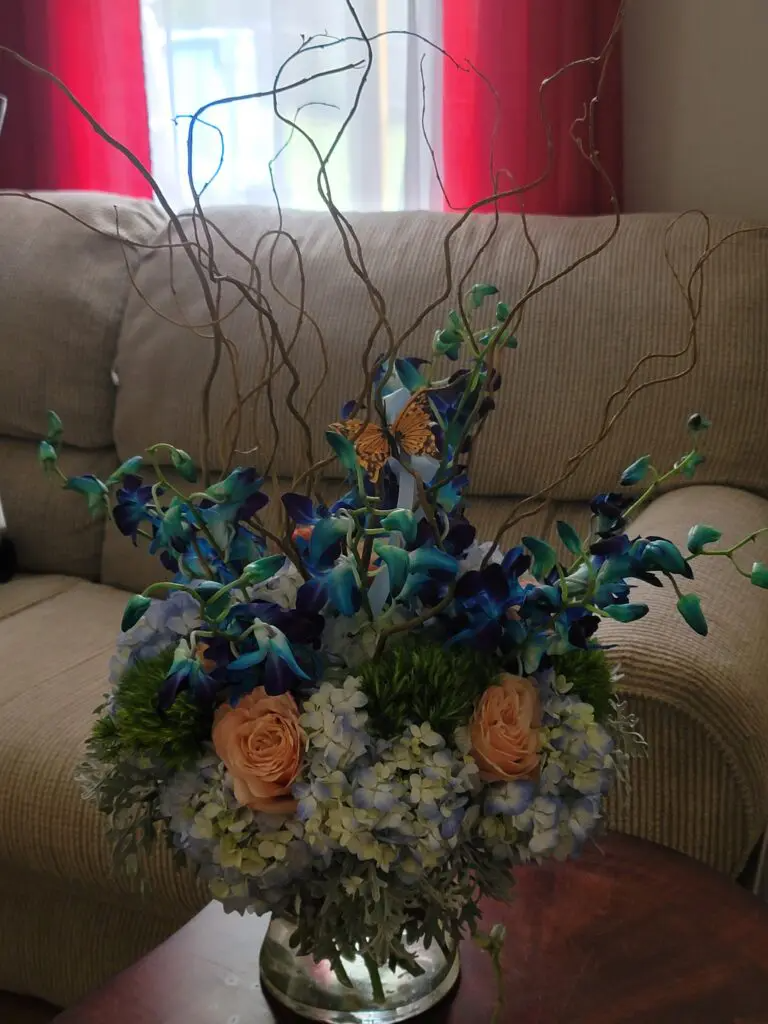 A vase filled with flowers is sitting on a table in front of a couch.