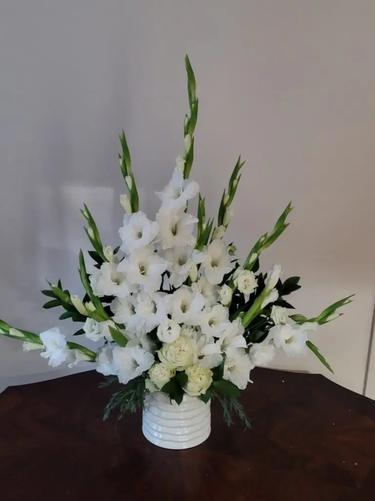 A vase filled with white flowers is sitting on a table.