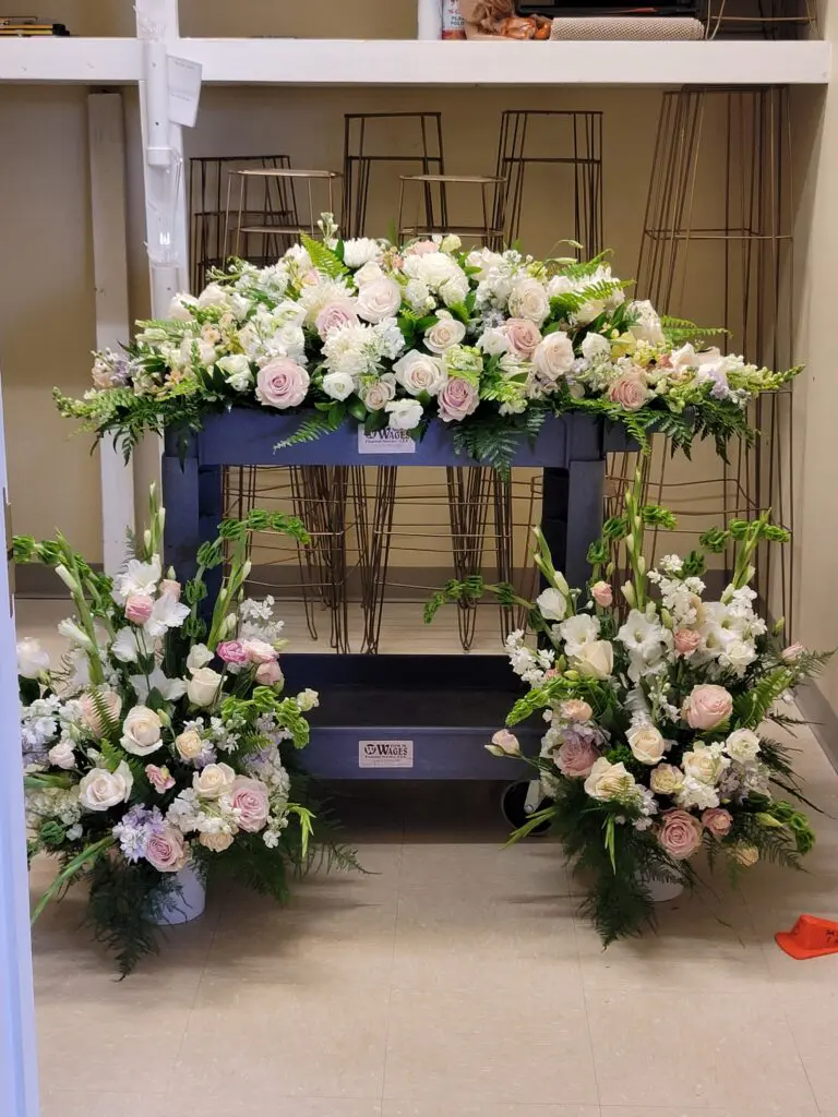 A bunch of flowers are on a cart in a room.