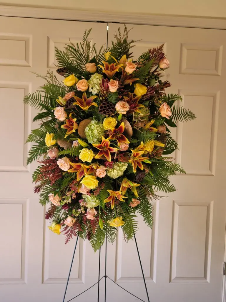 A floral arrangement is sitting in front of a white door.