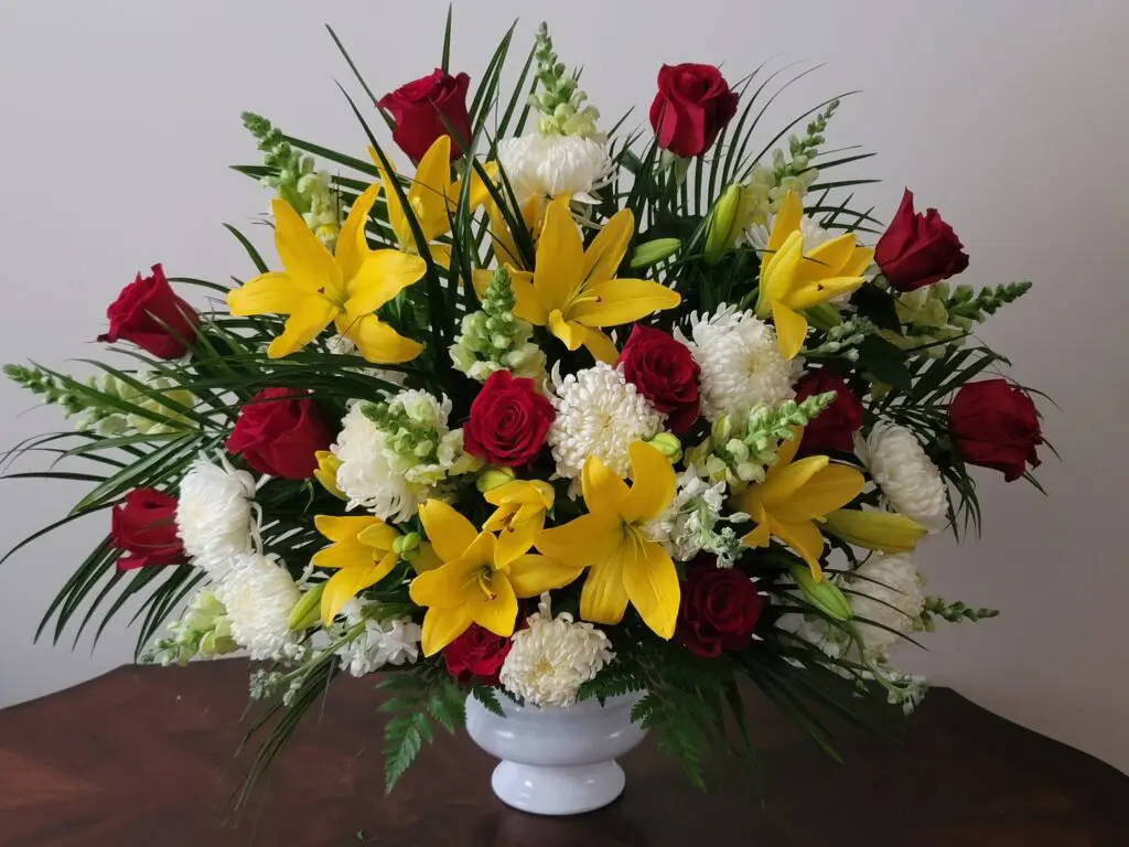 A vase filled with yellow and red flowers on a table