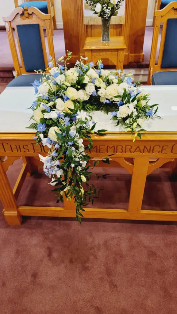 A table with flowers on it in a church.